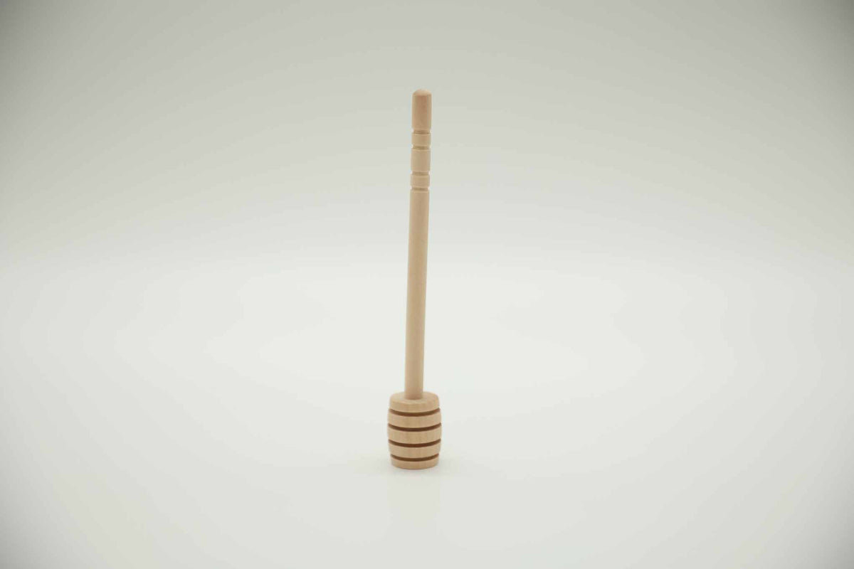 Honey dipper stick lifestyle — wooden dipper with raw honey on toast or cheese board