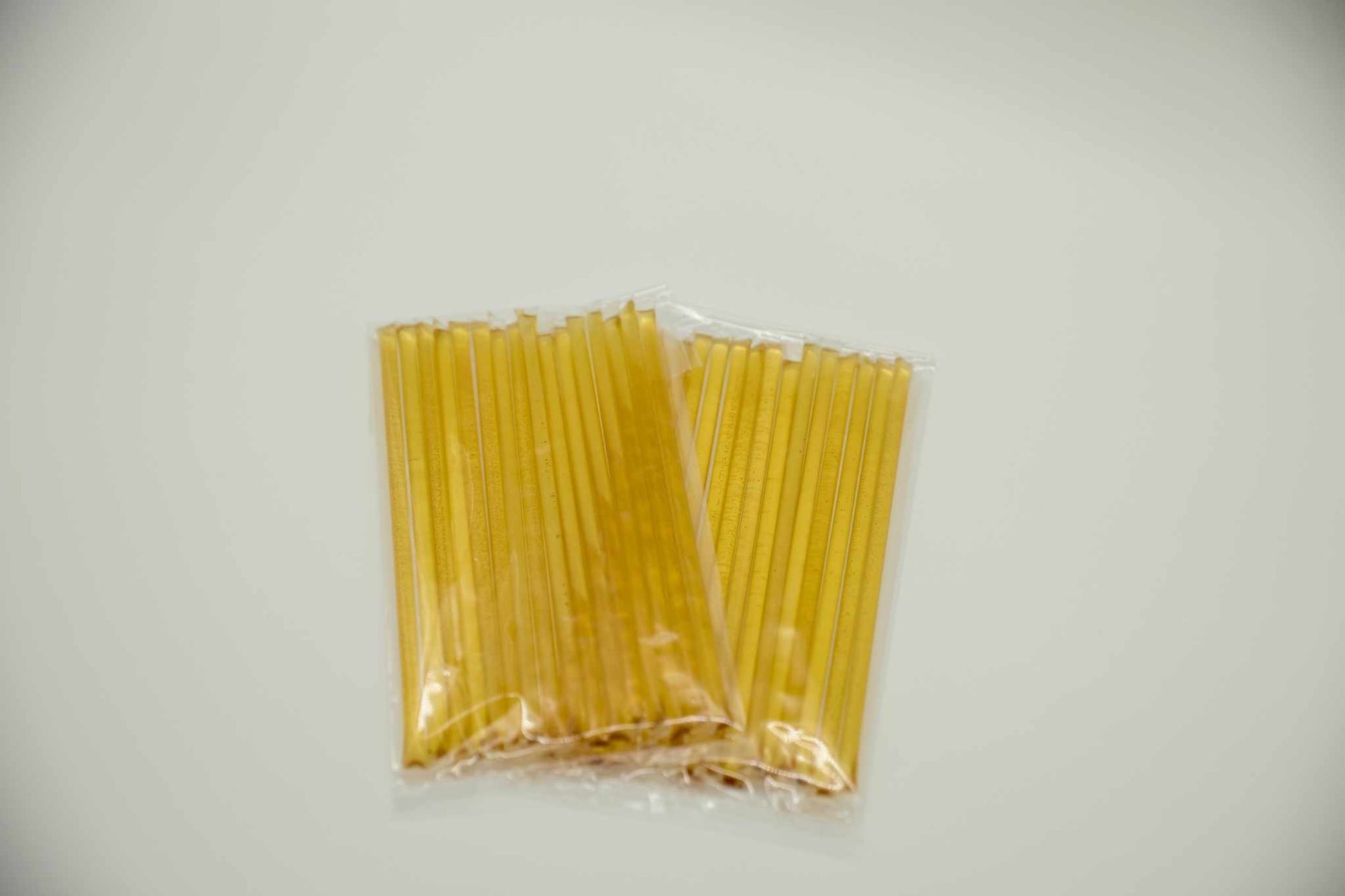 Close up of a clear honey stick showing the natural color of raw unpasteurized honey.